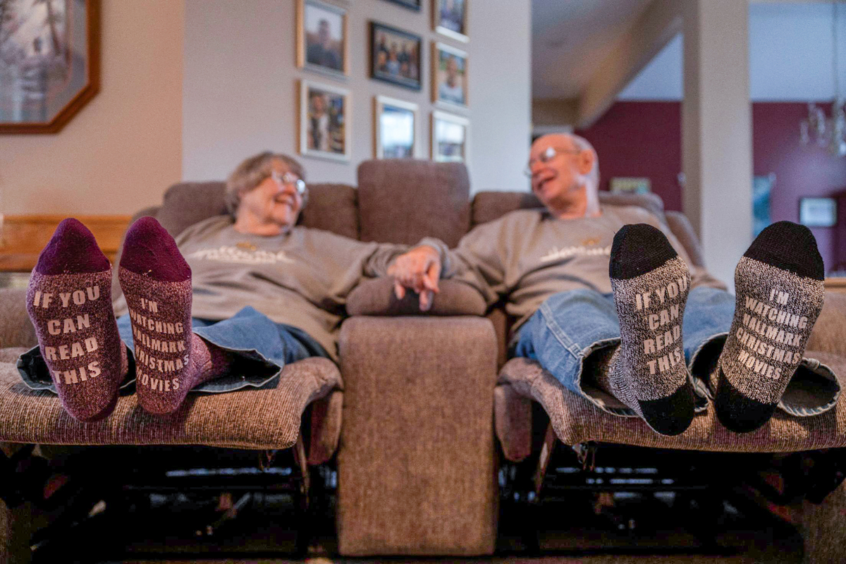 Cheryl and Joe Maggio show off their newly gifted socks while watching a Hallmark Christmas movie recently in their Olathe home.