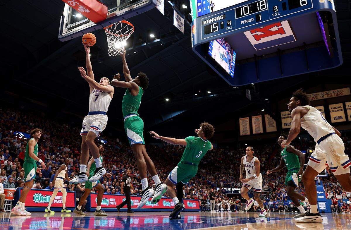 Kohl Rosario #7 of the Kansas Jayhawks drives to the basket as Devon Kobi Pearson #5 of the Texas A&M-Corpus Christi Islanders defends during the first half of the game at Allen Fieldhouse on November 11, 2025 in Lawrence.