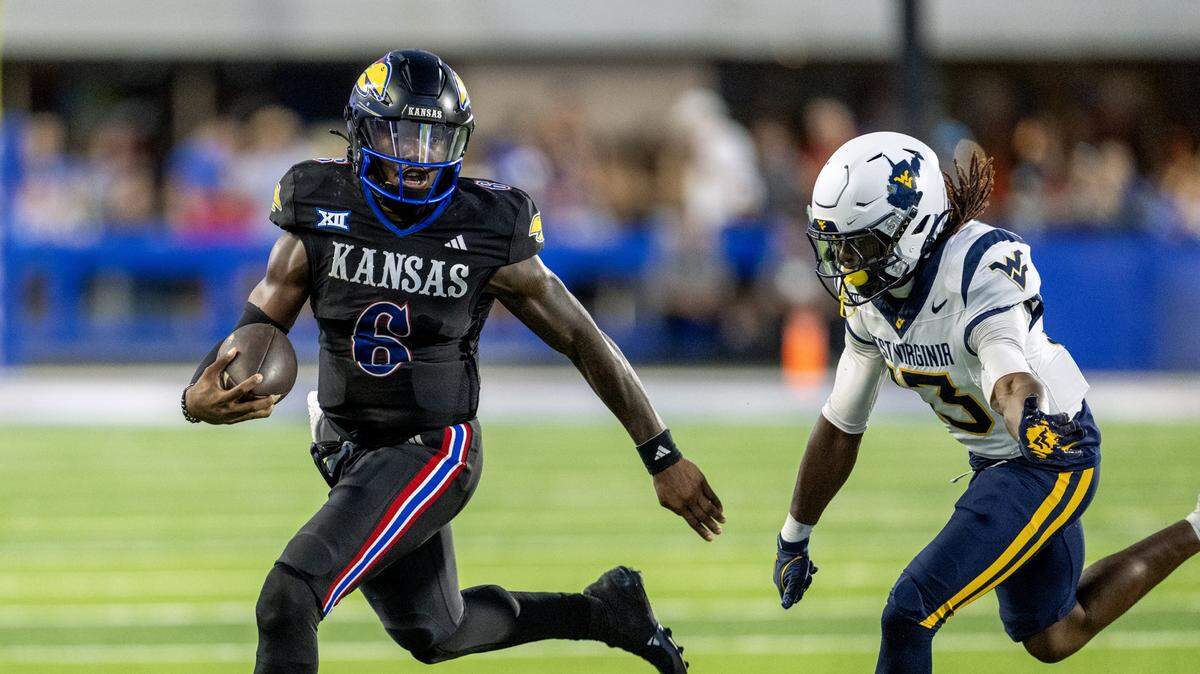 Kansas Jayhawks quarterback Jalon Daniels (6) gets past West Virginia Mountaineers cornerback Derek Carter Jr. (13) in the second half of the game at David Booth Kansas Memorial Stadium on Saturday, Sept. 20, 2025, in Lawrence.