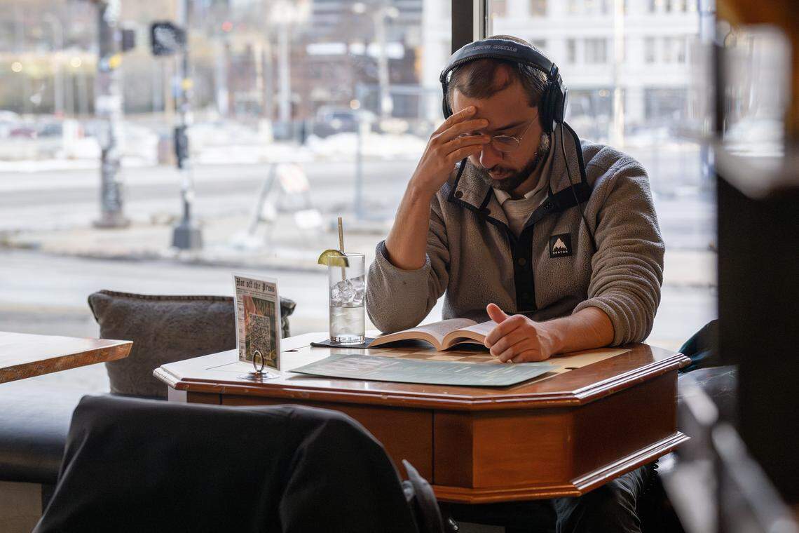 A guest reads at a table inside Afterword on Wednesday, Dec. 3, 2025, in Kansas City.