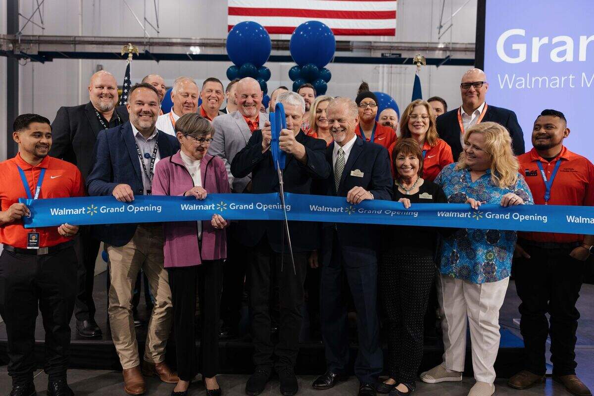People cut a blue ribbon that says "Walmart Grand Opening."