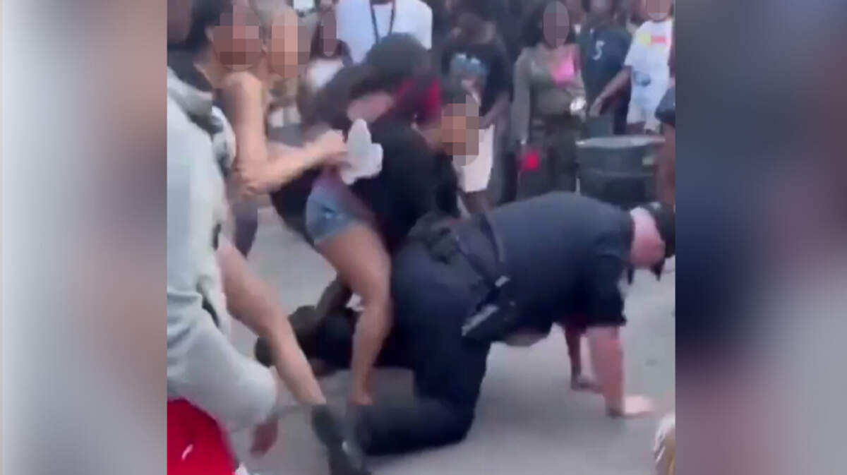 Video circulating in social media shows a group of young people swarming a police officer while he was on his knees on the ground at Downtown Days over the weekend.