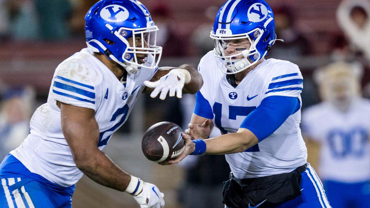 Brigham Young Cougars quarterback Jacob Conover (17) hands off to Brigham Young Cougars running back Christopher Brooks (2) against the Stanford Cardinal during the second half at Stanford Stadium.