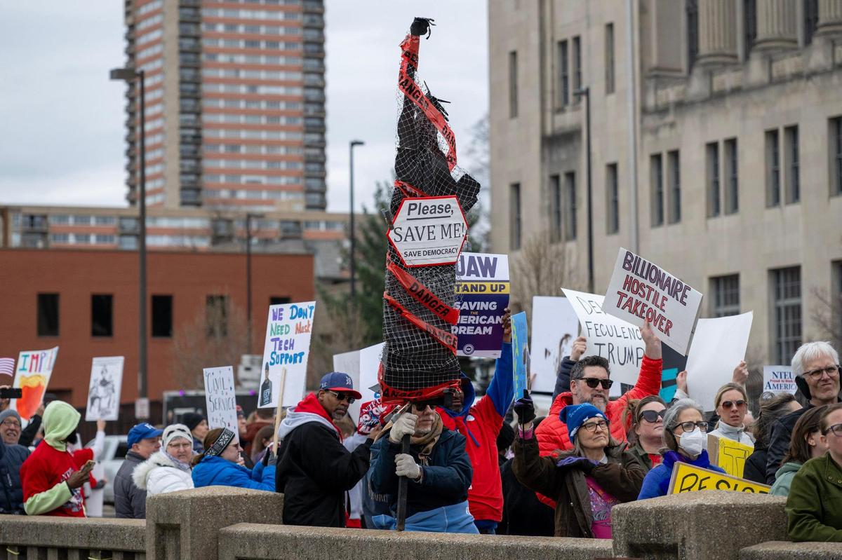 A crowd of demonstrators hold signs while rallying in support of federal workers on Saturday in Kansas City.