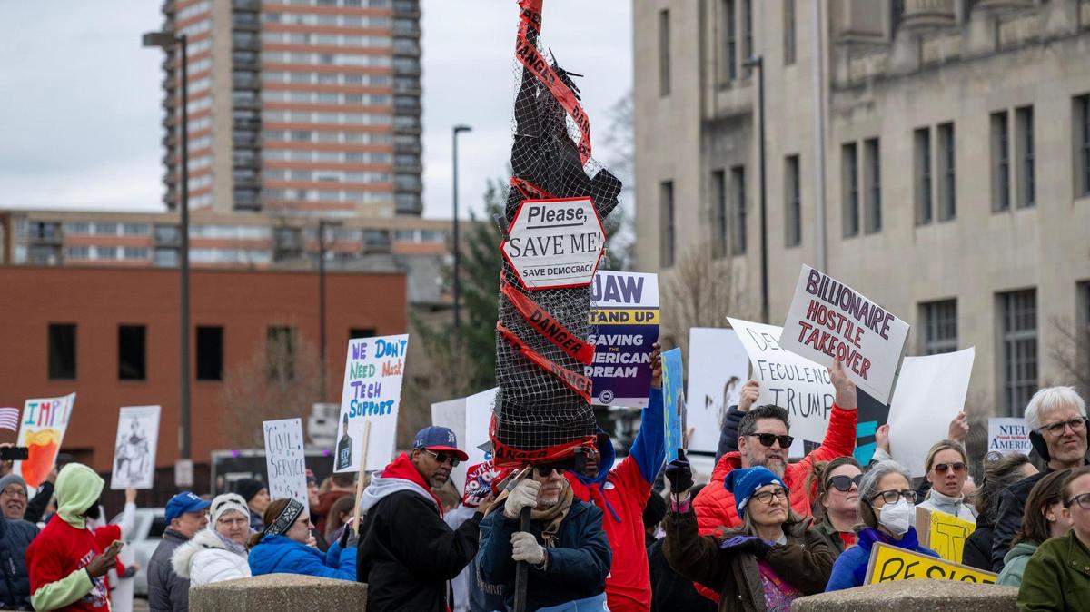 A crowd of demonstrators hold signs while rallying in support of federal workers on Saturday in Kansas City.