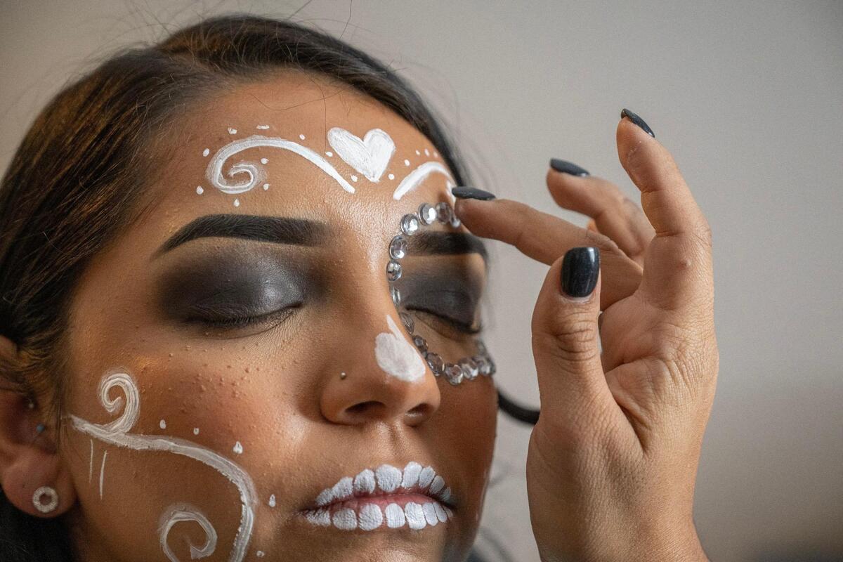 Briones adds jewels around Zenaida Estrada’s eyes to finish the Catrina makeup.