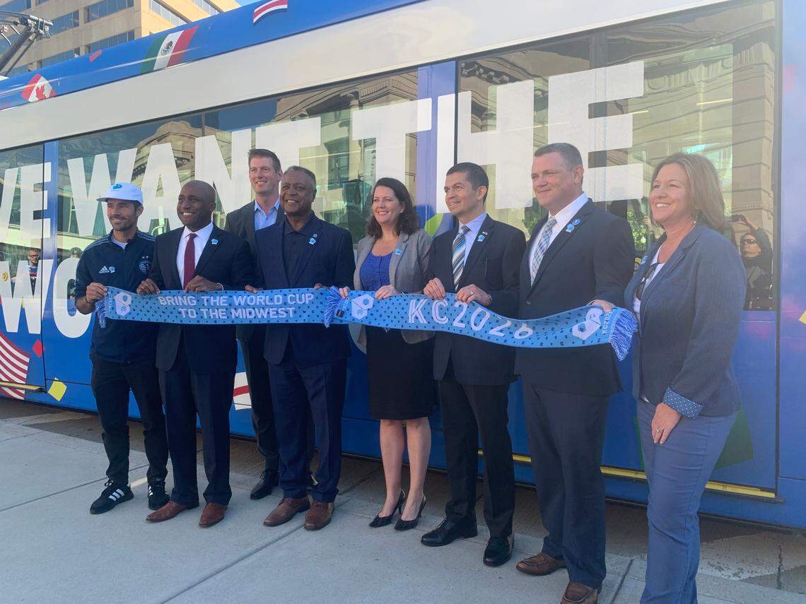 Members of Kansas City’s World Cup host city bid committee, including director Katherine Fox, Kansas City, Missouri mayor Quinton Lucas and Jackson County executive Frank White, show off a new streetcar wrap.
