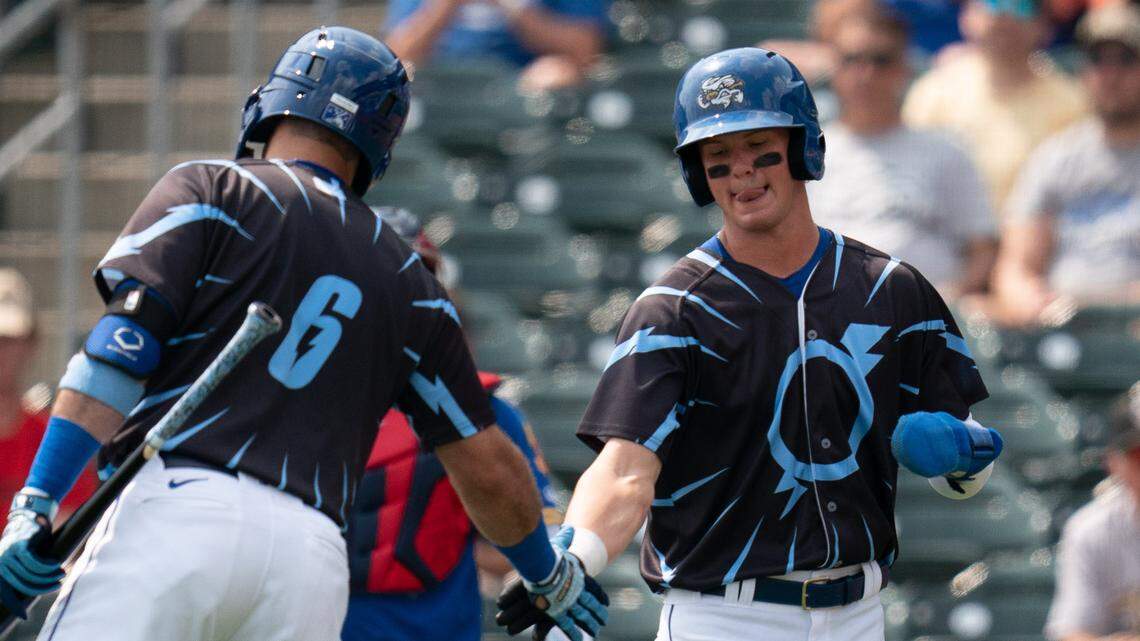 Bobby Witt Jr., right, is congratulated by a new Omaha Storm Chasers teammate after scoring his first Triple-A run Tuesday in Omaha, Neb.