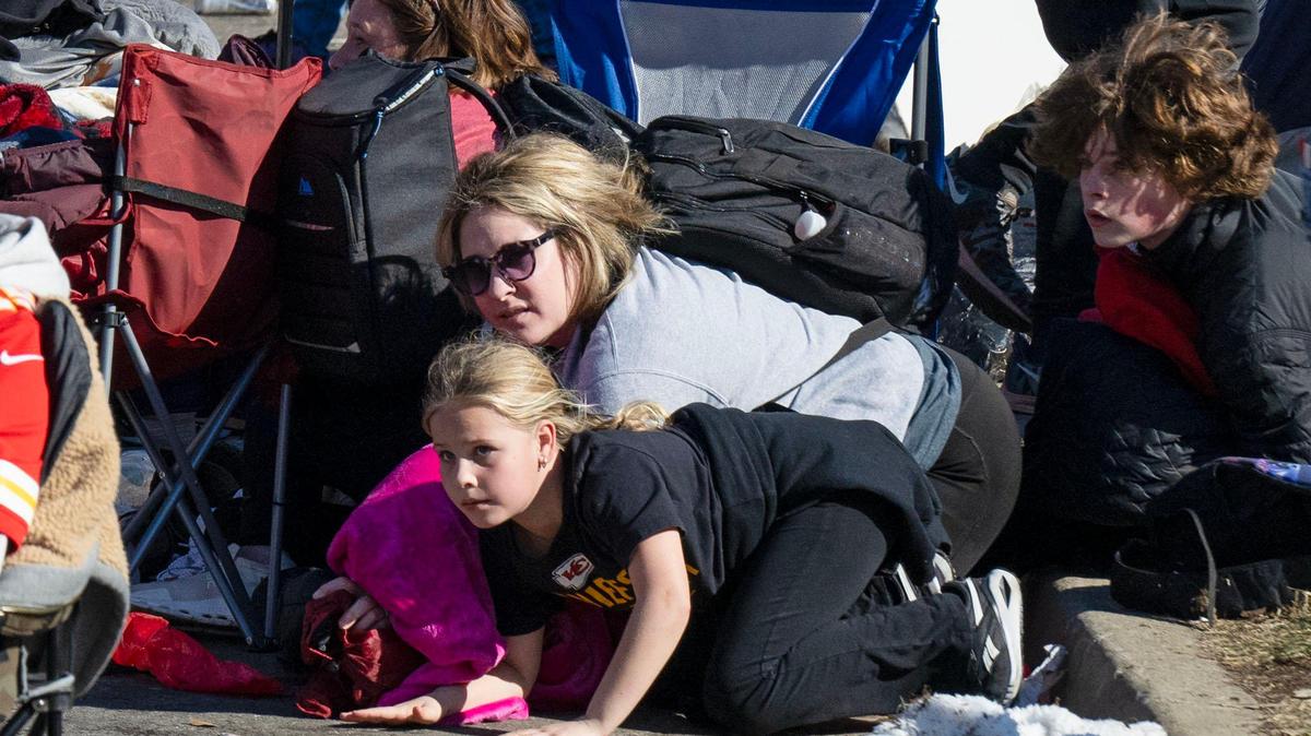 Kansas City Chiefs fans take cover after shots were fired at the conclusion of the Super Bowl Championship rally on Feb. 14, at Union Station in Kansas City. Twenty-two people were shot, including one fatally.