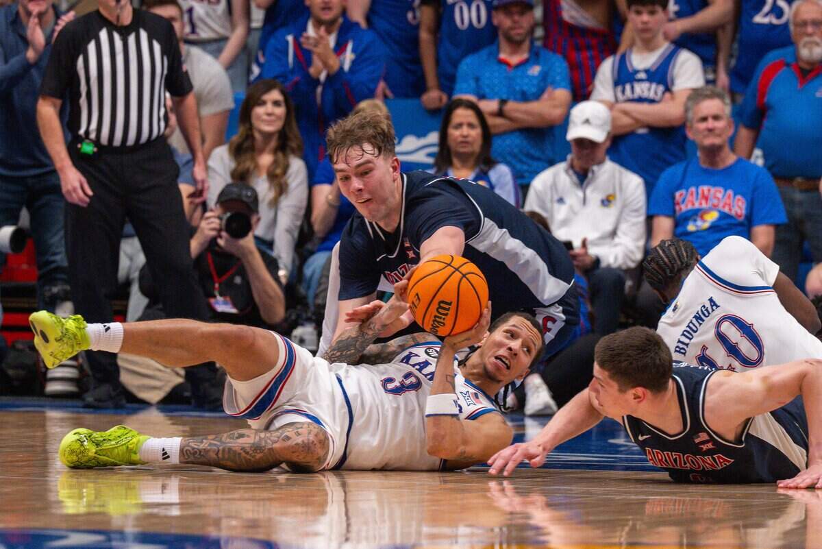 Kansas Jayhawks guard Tre White (3) dives on the floor for a loose ball against Arizona Wildcats center Motiejus Krivas (13) in the second half on Monday, February 9, 2026, at Allen Fieldhouse.