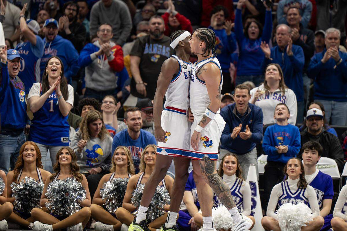 Kansas guard Melvin Council Jr. (14), left, and Kansas guard Tre White (3) chest bump after White made a layup during the first half of a Big 12 Men's Basketball Tournament game against the TCU Horned Frogs at T-Mobile Center on Thursday, March 12, 2026, in Kansas City.