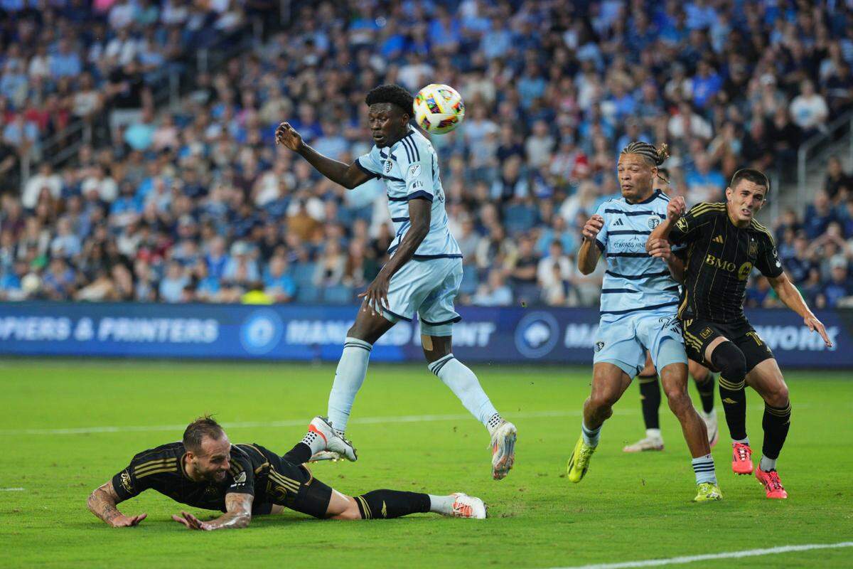 Sporting Kansas City forward Stephen Afrifa leaps overs LAFC defender Maxime Chanot during Saturday night’s MLS match at Children’s Mercy Park in Kansas City, Kan.