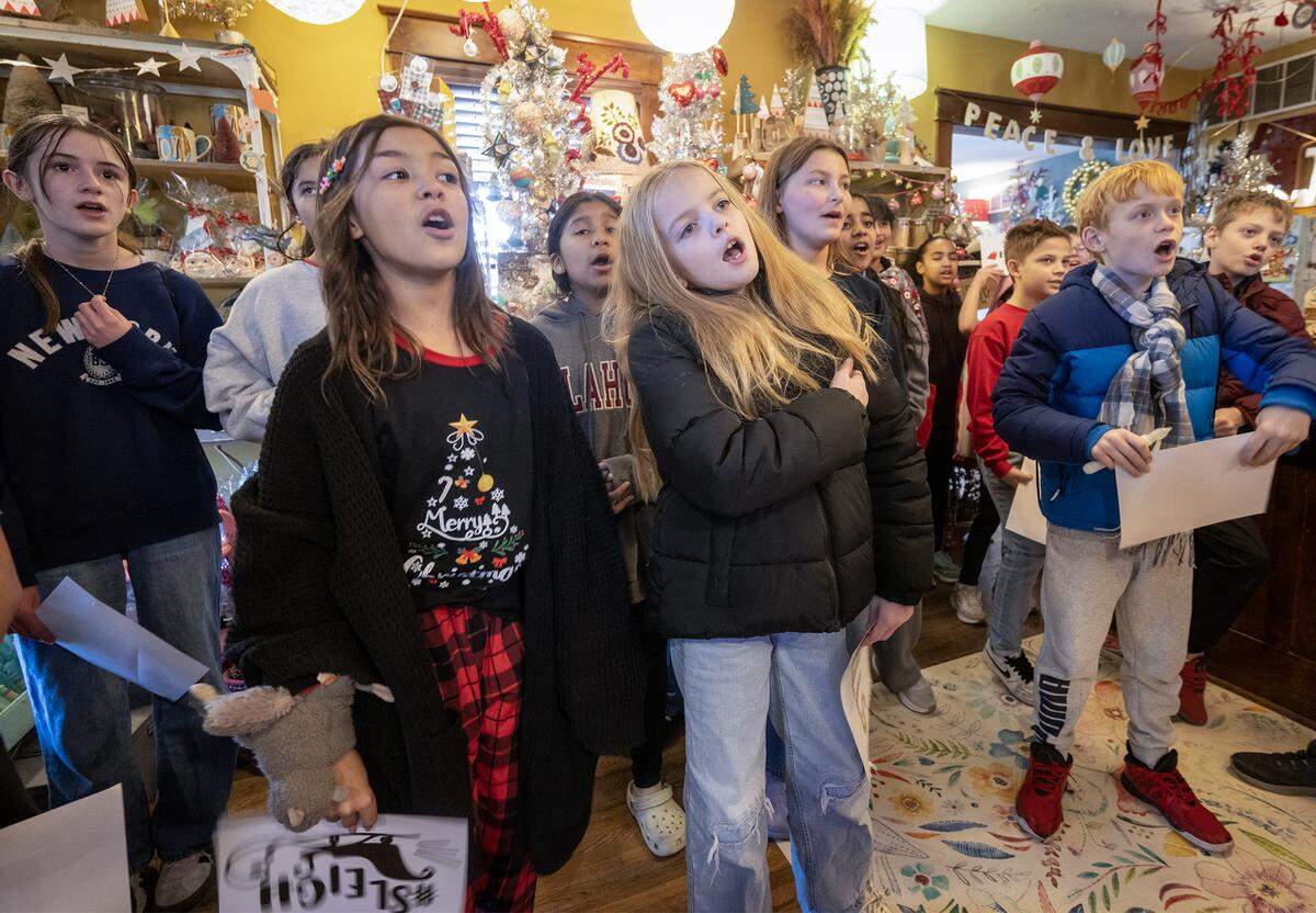 Under the direction of music teacher Rachel Marlow, special chorus students from Central Middle School, including from left, Vivian Waters, 5th grade, and fourth graders Shilah Waller, Remi Slyter,  Eli Mowry, sing Christmas carols during a stop at Junque Drawer Studio in downtown Olathe on Wednesday, Dec. 17, 2025. 