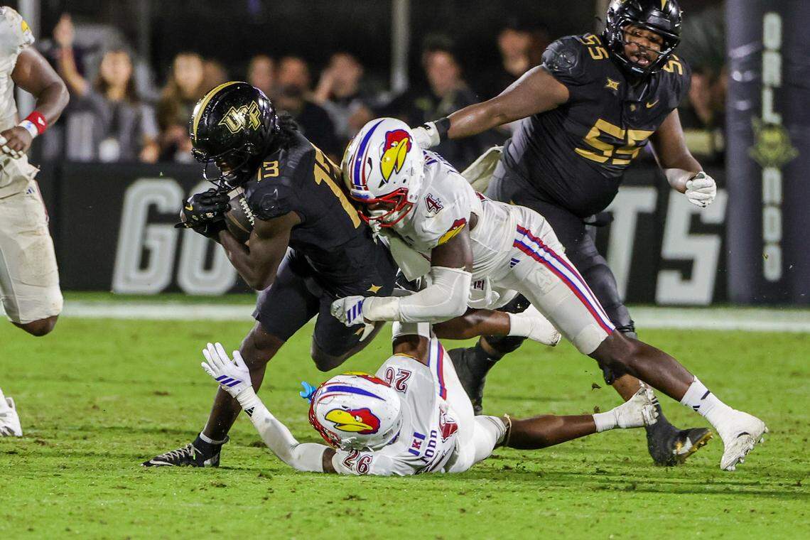 UCF Knights wide receiver Chris Domercant (13) is tackled by Kansas Jayhawks linebacker Trey Lathan (4) during the second half in Orlando on Oct. 4, 2025.