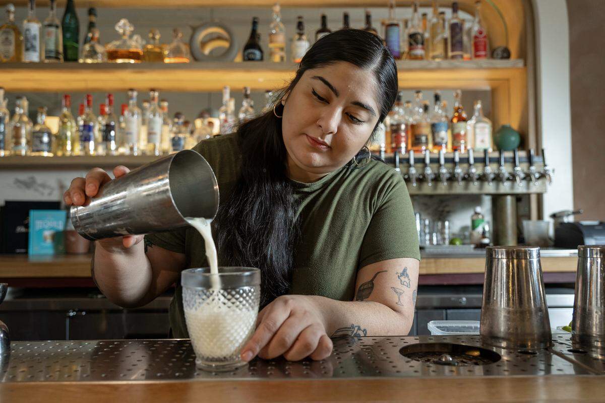 Diana Condori, a bartender at Fern Bar, pours a Piña Colada on Thursday, March 5, 2026. The cocktail features a house rum blend, Clément Coconut, coconut cream, pineapple, and lime. Condori is a 2026 James Beard Award nominee for Outstanding Professional in Cocktail Service.