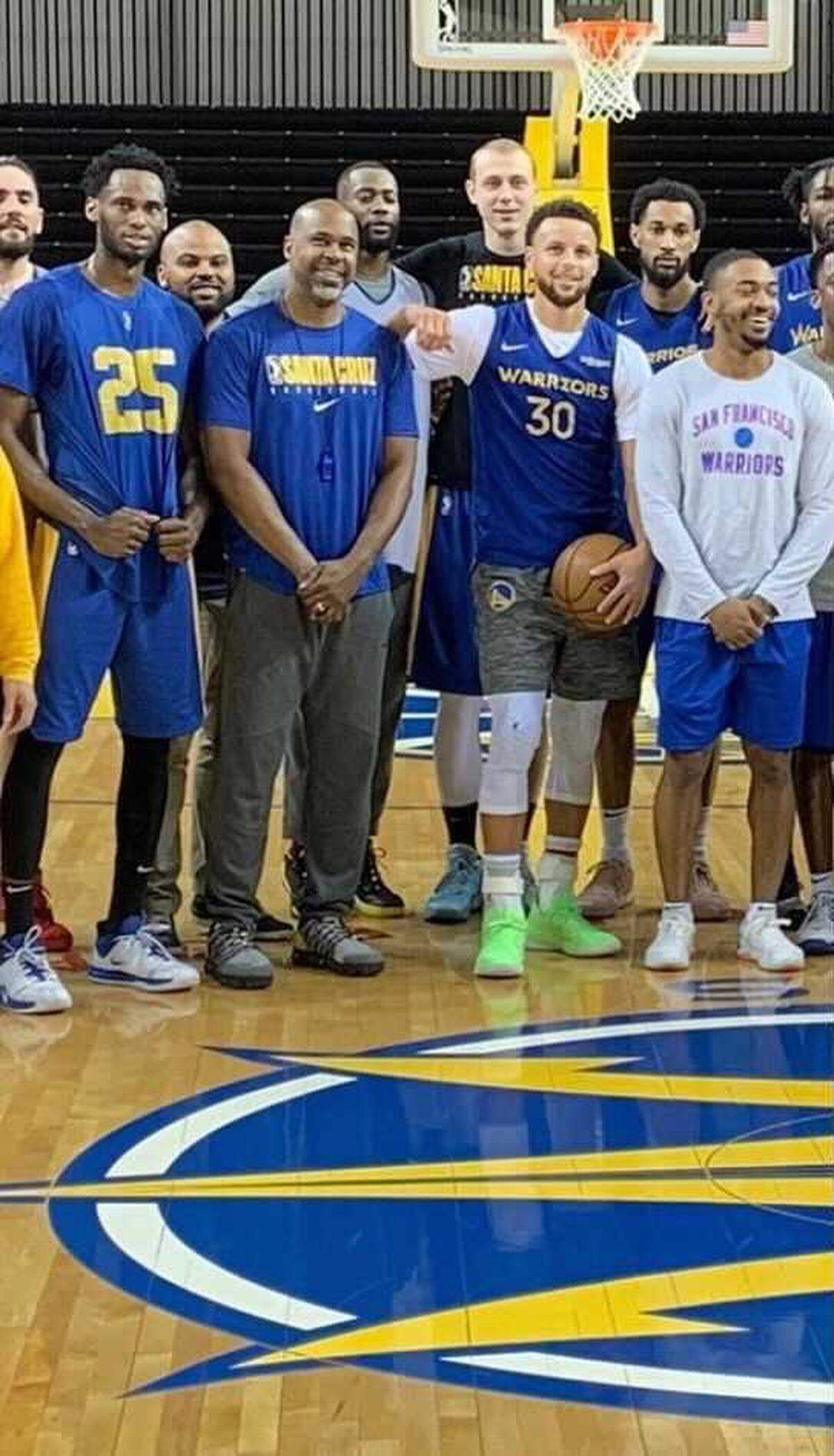 Warriors assistant coach Kris Weems (second from left, front row) takes a team photo alongside point guard Stephen Curry (third from left) and other Golden State players.
