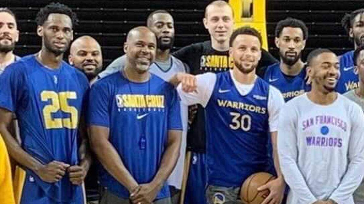Warriors assistant coach Kris Weems (second from left, front row) takes a team photo alongside point guard Stephen Curry (third from left) and other Golden State players.