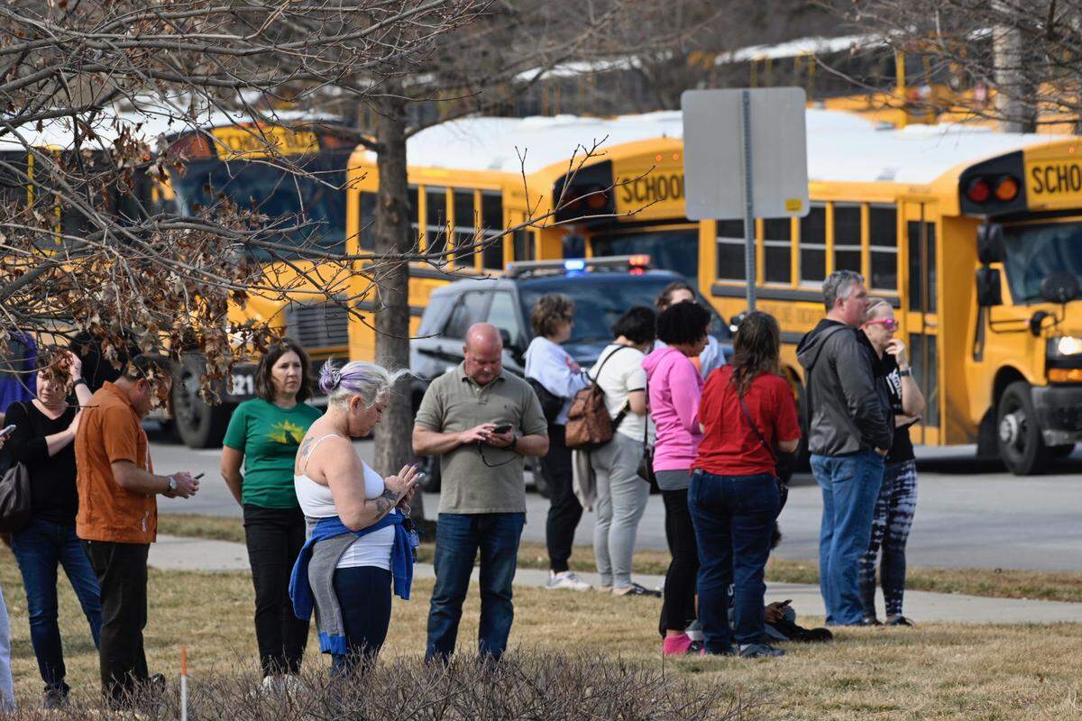 Parents of Olathe East High School students wait at the reunification site near 127th and South Black Bob Friday after a school shooting at Olathe East High School. Police report two people were shot and injured at the school. The shooter is in custody.