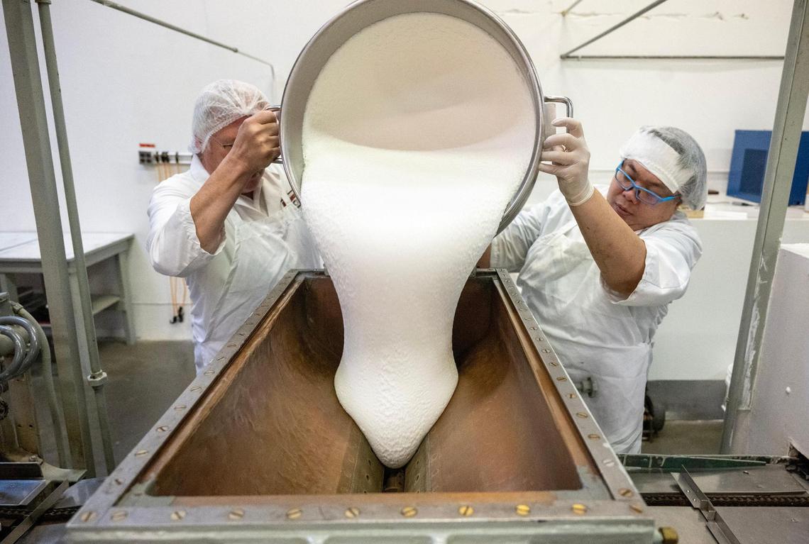 Dave Swiercinsky, left, and Bob Khotbounheuan pour a 140-pound vat of marshmallow cream while making Sifers Valomilks at the Merriam, Kansas, production facility.