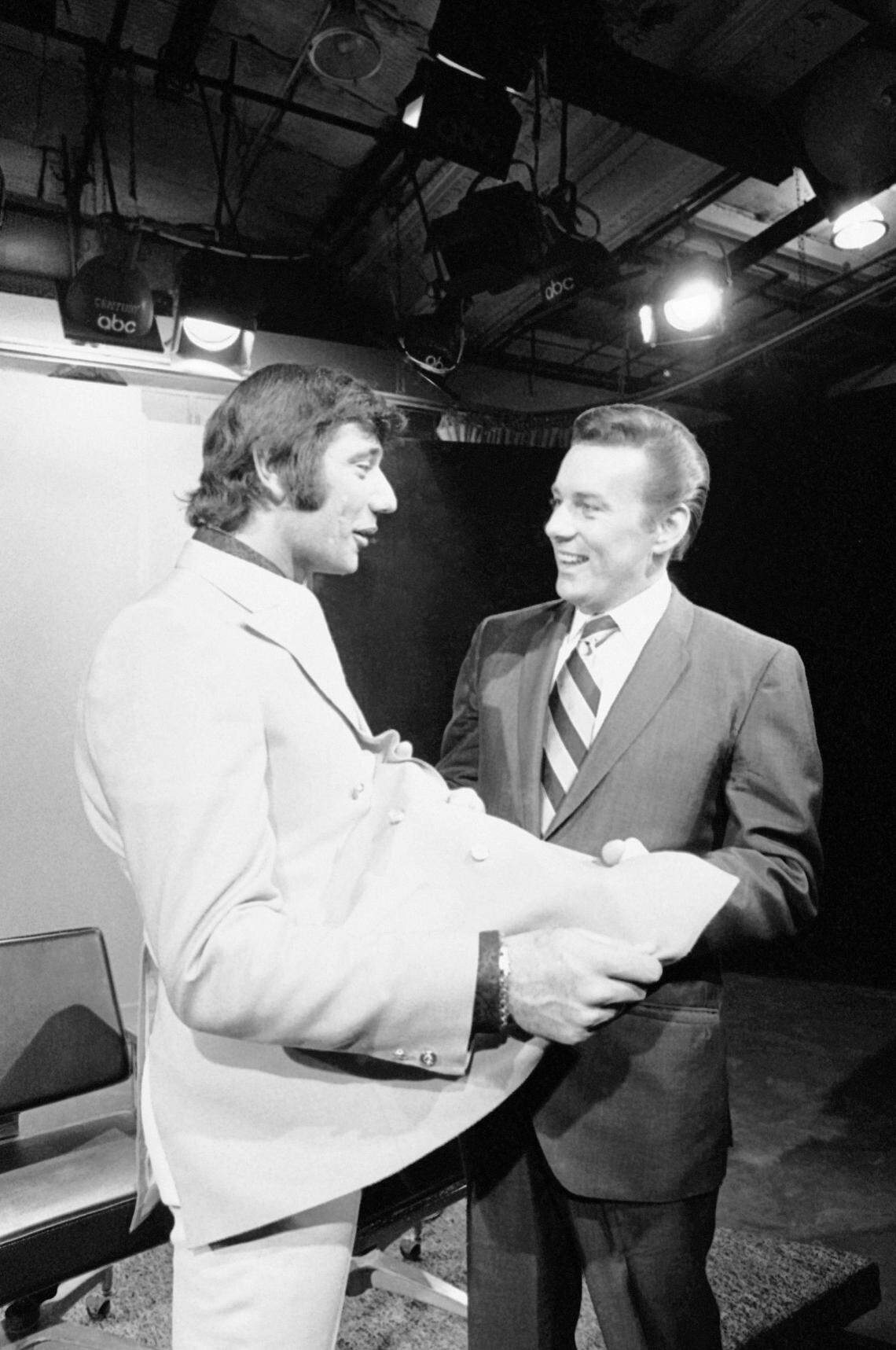 New York Jets quarterback Joe Namath, left, and Kansas City chiefs quarterback Len Dawson, right, talk during the Jan. 15, 1970, taping in New York of an American Broadcasting Company TV program reviewing Super Bowl IV. Dawson is seen admiring Namath’s jacket during taping session.