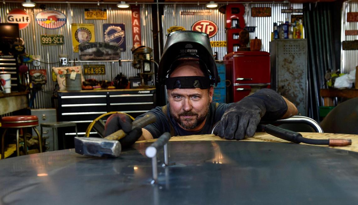 Brad Easley eyes a snuffer lid handle to make sure it’s straight before welding it on.