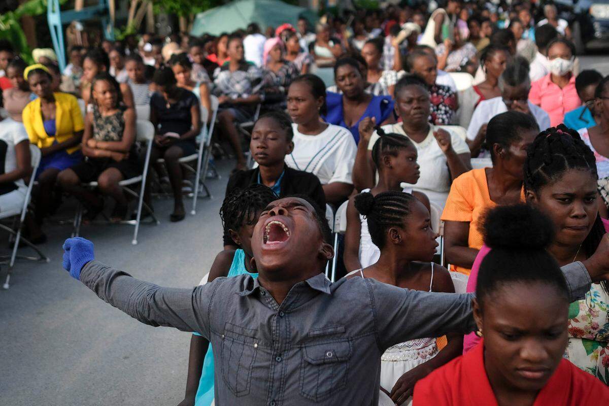 A parishioner shouts “ Hallelujah” during a mass on the grounds Sunday next to an earthquake-damaged church in Les Cayes, Haiti, eight days after a 7.2 magnitude earthquake hit the area.