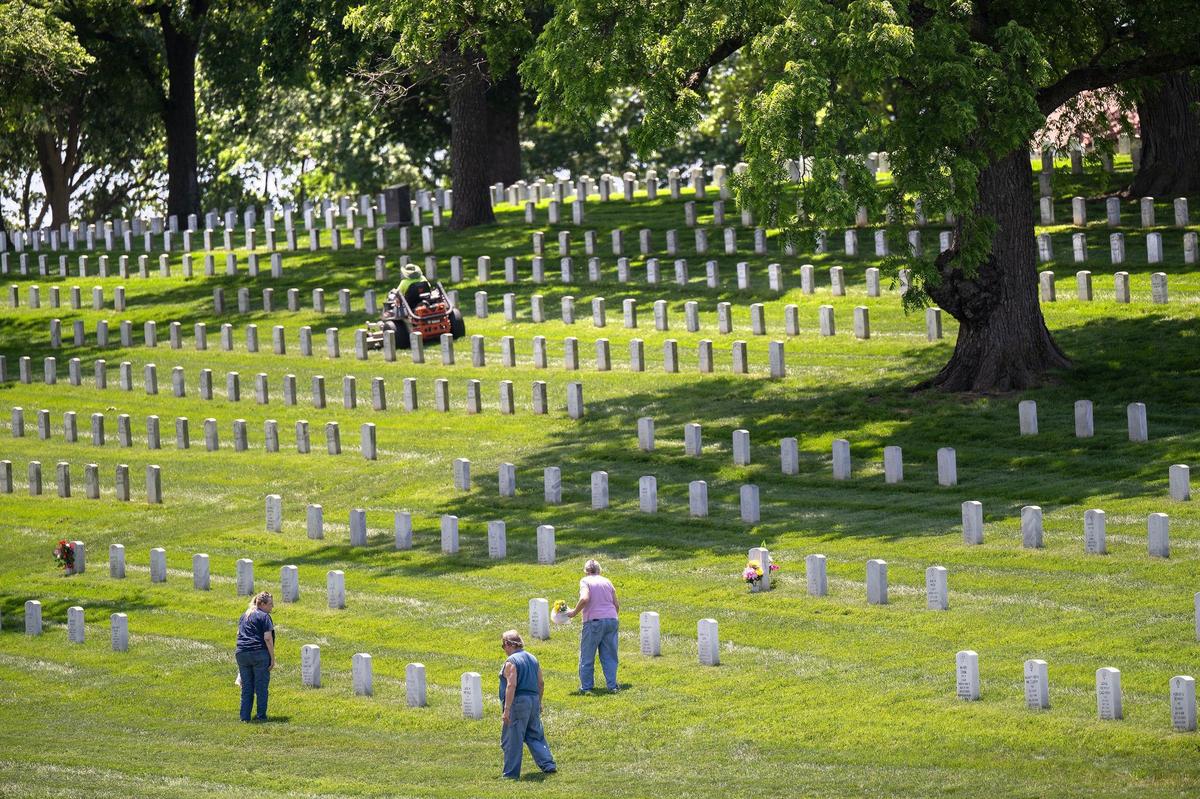 Grace Rice-Raymond, from left, and her cousins, Dave Fuller, and Joy Peacher, all of Kansas City, Kansas, look for the graves of seven family members to pay their respects and leave flowers at their graves at Leavenworth National Cemetery on Thursday, May 23, 2024, ahead of the Memorial Day holiday.
