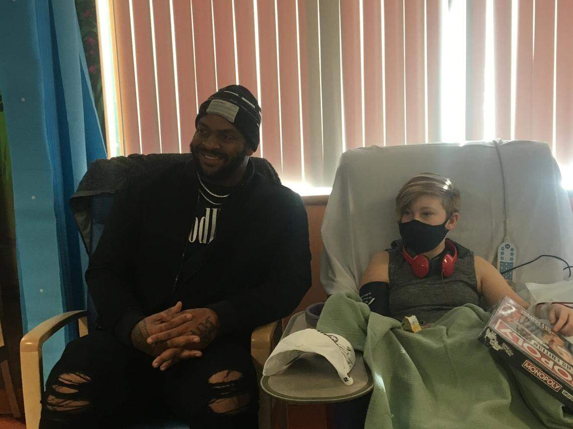 Kansas City Chiefs defensive lineman Mike Pennel returned to Children’s Mercy Hospital to visit with patients, including T (right). Pennel was treated for a form of kidney cancer at the hospital when he was 2.