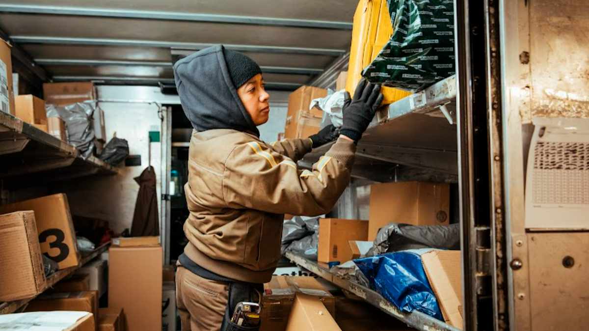 A UPS worker sorts packages in the back of a delivery truck. The company plans to hire around 2,000 temporary workers in the Kansas City area this holiday season.