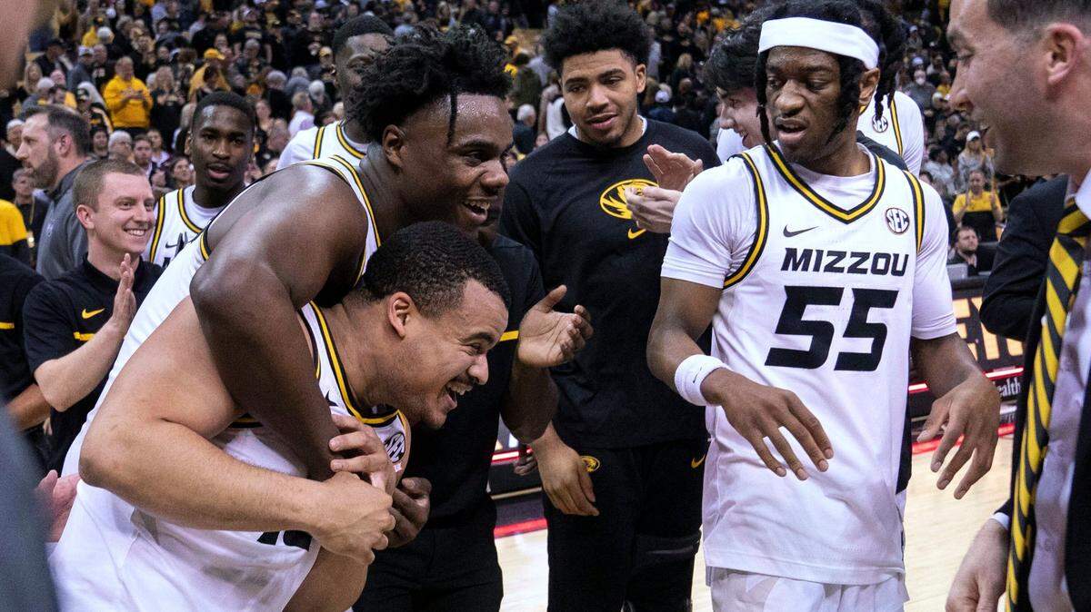 Missouri’s Nick Honor, bottom left, is hugged by Kobe Brown as Sean East II watches after Honor’s game-winning basket in overtime against Mississippi State on Feb. 21, 2023.