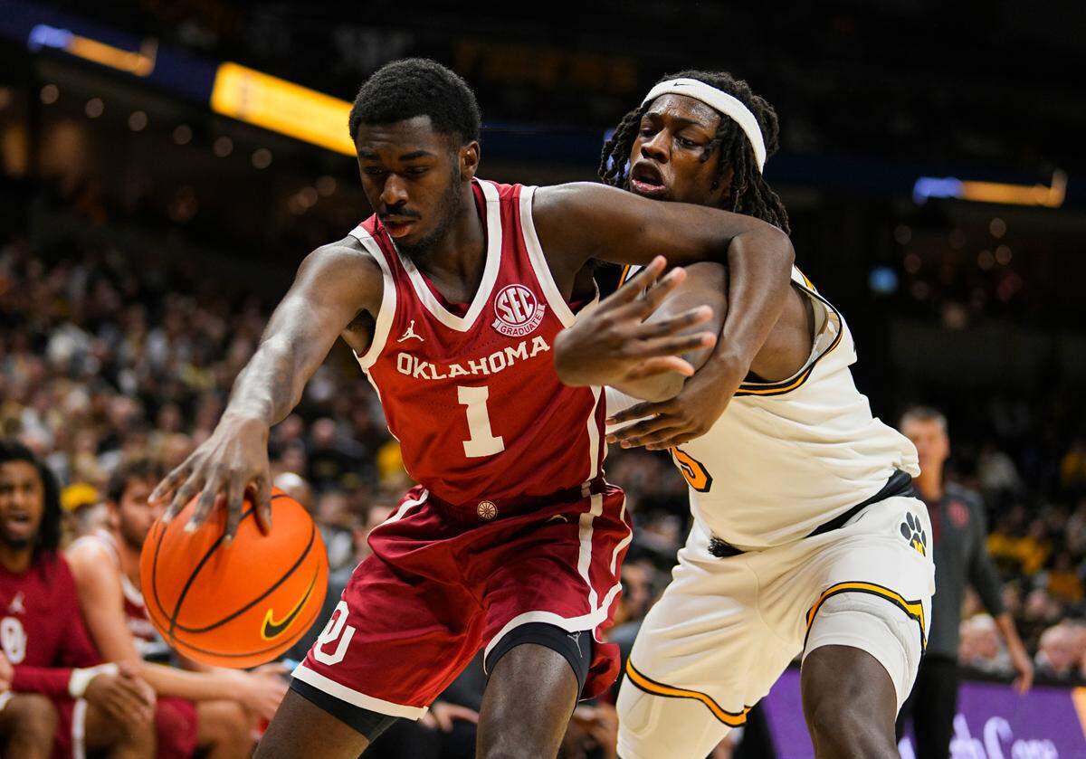 Oklahoma Sooners guard Kobe Elvis, left, tries to fend off Missouri Tigers guard Mark Mitchell while scrambling for a rebound during an SEC men’s basketball game Mizzou Arena in Columbia on Wednesday, Feb. 12, 2025.