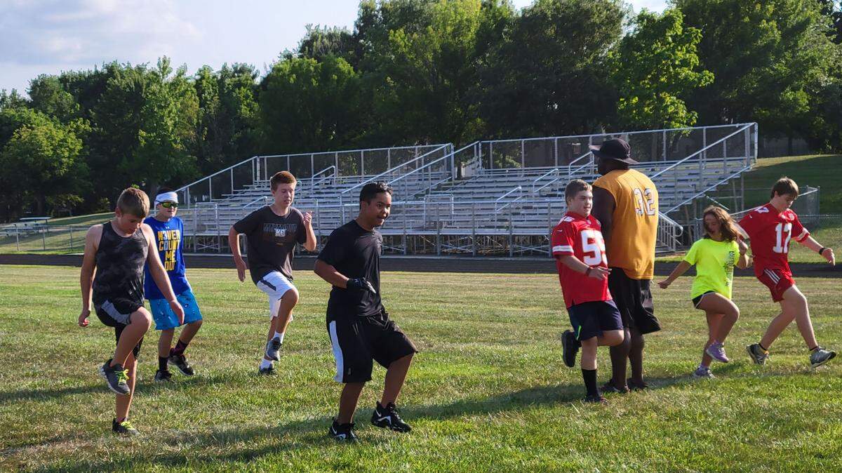 Oren Thurber, from left, and teammates Miles Dimino, Colten Shields, Julius Jones, Owen Merritt, Joslyn Sabol and Nolan Skelsey run drills with Coach Justin Jones as they prepared for Flag Football season.