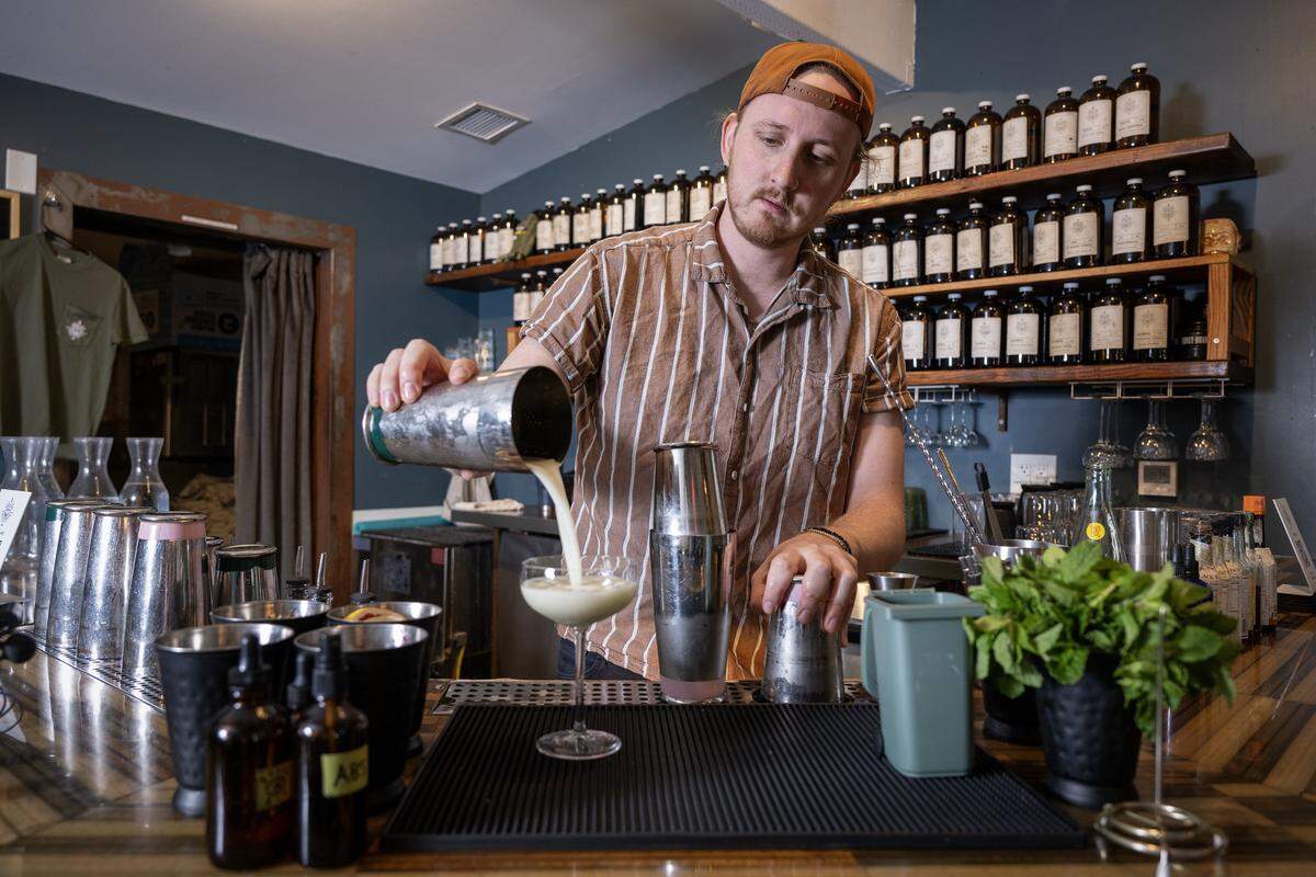 Nate Tallman, left, the bar manager at Drastic Measures, pours a Greener Pastures cocktail on Thursday, March 12, 2026, at the downtown Shawnee bar. Drastic Measures is once again a semifinalist for a James Beard Award in the Outstanding Bar category.