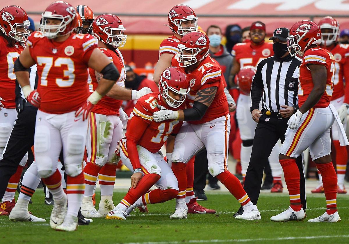 Kansas City Chiefs quarterback Patrick Mahomes is steadied by offensive tackle Mike Remmers after taking a hard hit from the Cleveland Browns in the third quarter Sunday, January 17, 2021, at Arrowhead Stadium in Kansas City, Missouri.