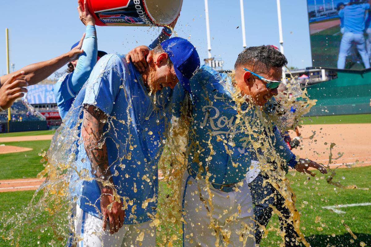 Kansas City Royals starting pitcher Cole Ragans (55) and catcher Freddy Fermin (34) are doused by shortstop Bobby Witt Jr. (7) and outfielder MJ Melendez (1) after the win over the Detroit Tigers at Kauffman Stadium on May 22, 2024 in Kansas City, Missouri, USA.