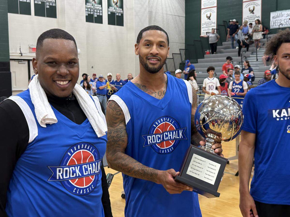 Travis Releford, right, holds his Rock Chalk Roundball Classic MVP trophy while visiting with fellow Blue team member Russell Robinson on Thursday, June 4, 2026 at Free State High in Lawrence, Kansas.