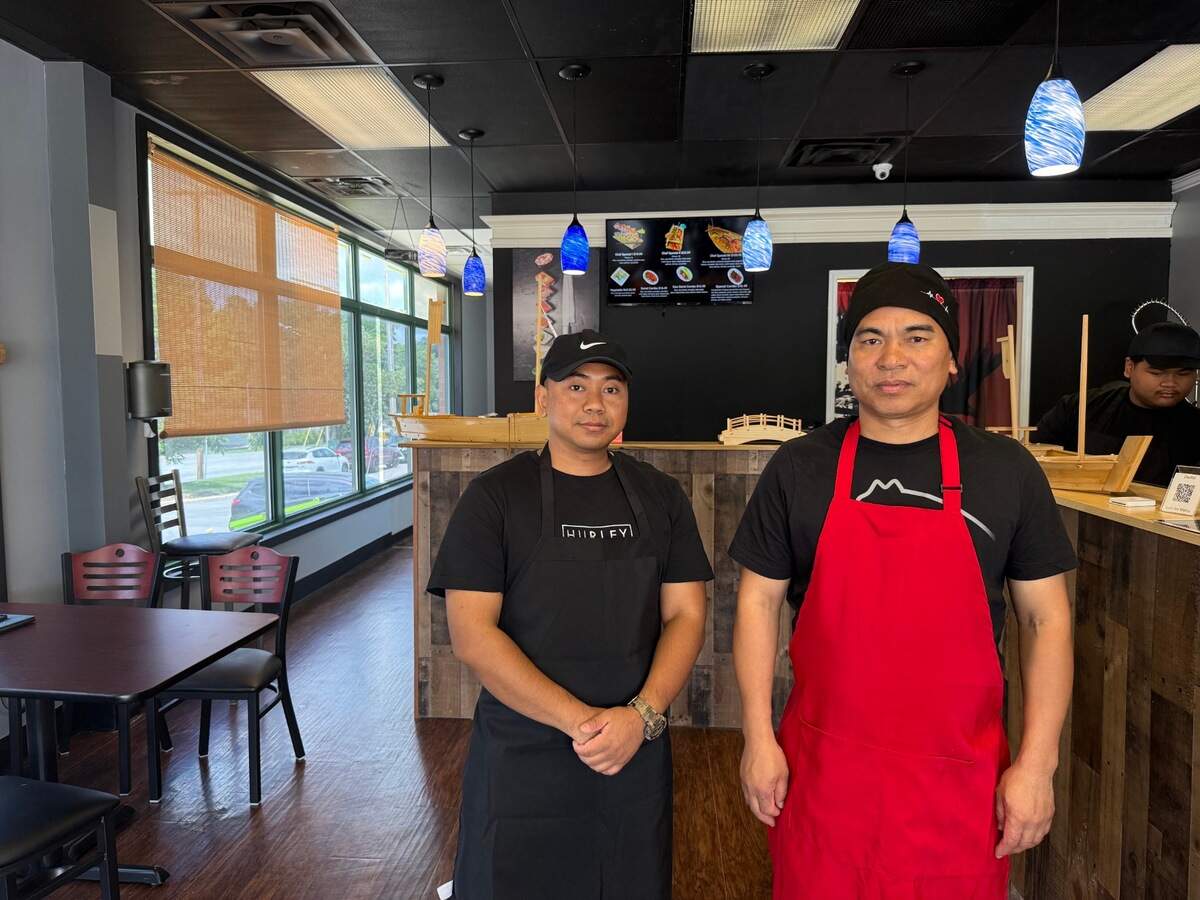 Daniel Hnin (left) and his chef and uncle, Mang Al, pose inside their new Shawnee restaurant.