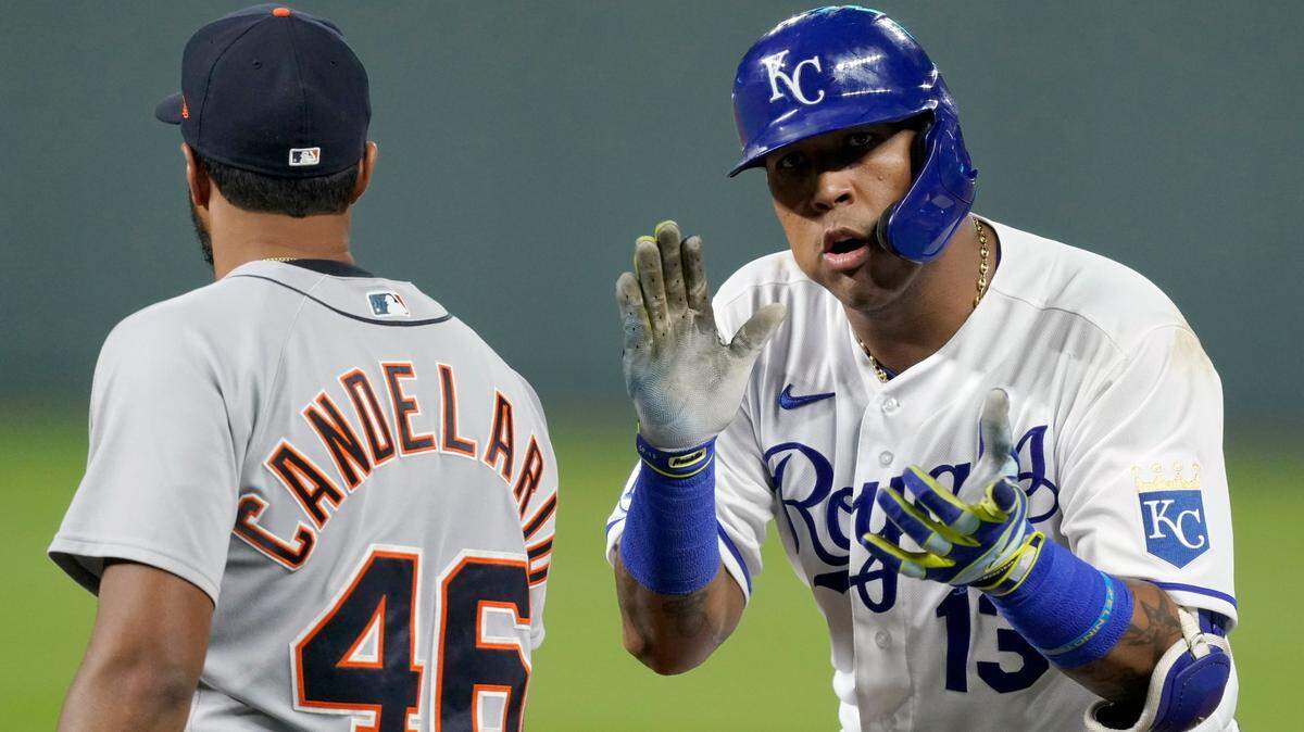 Kansas City Royals’ Salvador Perez (13) cheers while standing on base with Detroit Tigers first baseman Jeimer Candelario after hitting a single during the third inning of a baseball game Thursday, Sept. 24, 2020, in Kansas City, Mo. (AP Photo/Charlie Riedel)