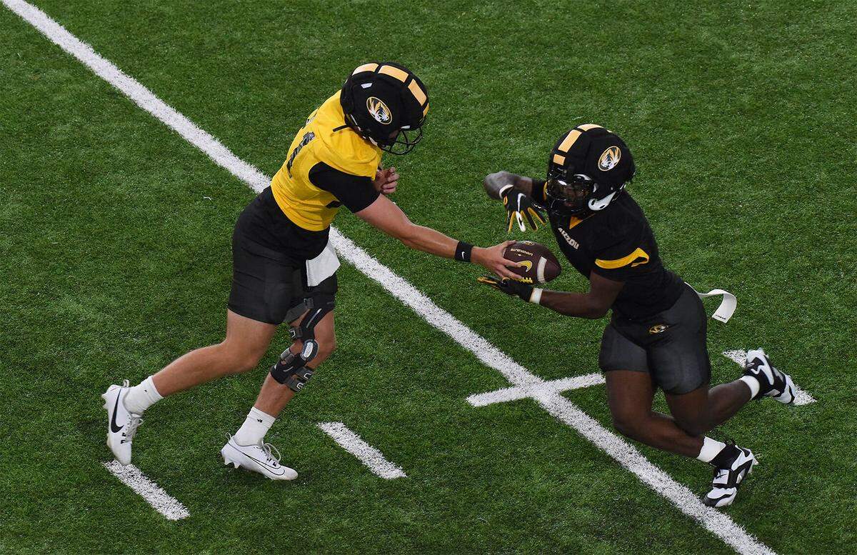 Missouri quarterback Sam Horn, left, hands the ball off during preseason camp on Tuesday, July 29, 2025.