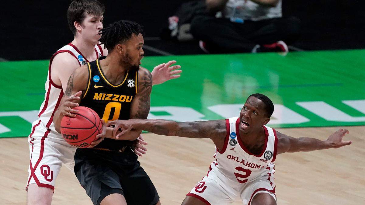 Missouri guard Torrence Watson (0) drives between Oklahoma guard Austin Reaves, left, and guard Umoja Gibson, right, during the first half of a first-round game in the NCAA men’s college basketball tournament at Lucas Oil Stadium, Saturday, March 20, 2021, in Indianapolis. (AP Photo/Darron Cummings)