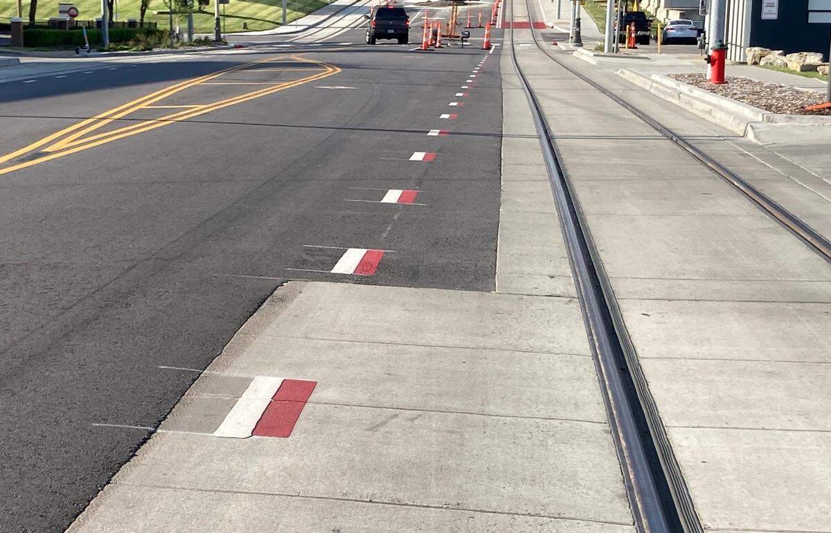 Red-and-white dashed line indicates that motorists can merge into the adjoining lane to make a turn at an intersection or into a drive or, in some cases, park on the street.