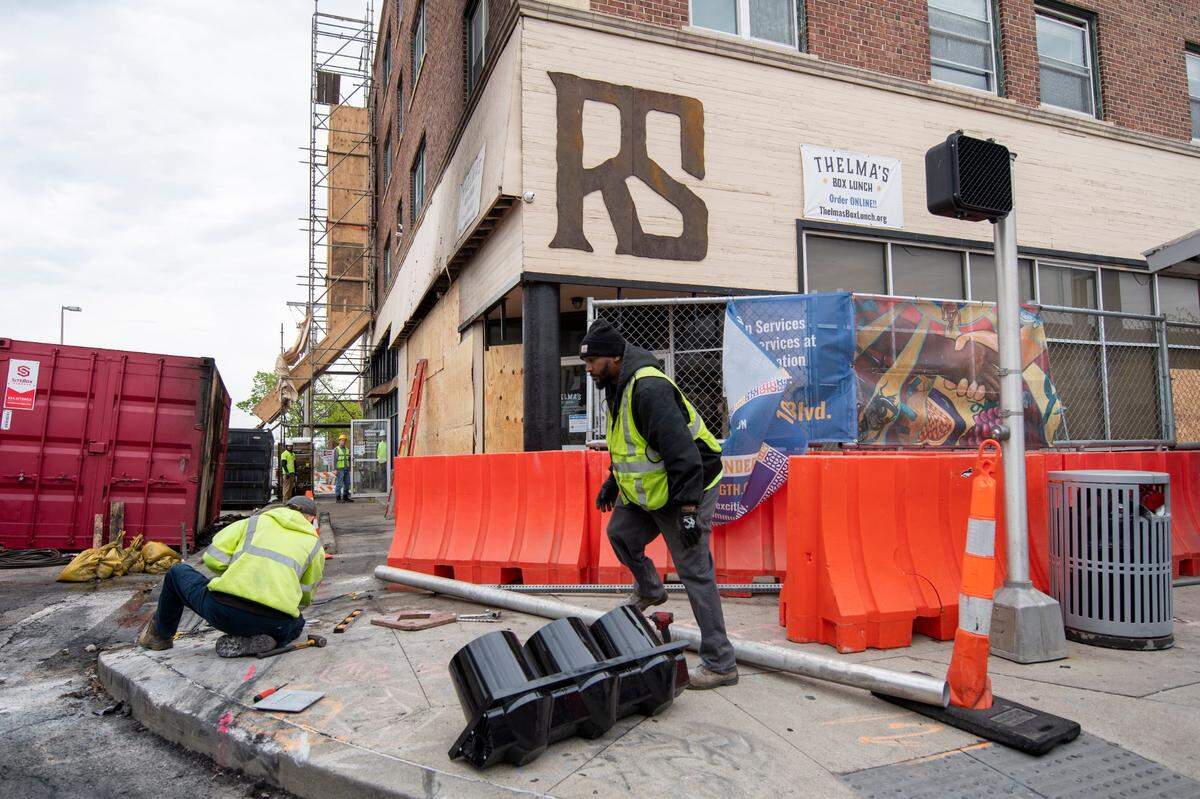 Two people died in a fiery, high-speed crash in May 2022 when the driver of a Corvette slammed into a building at 31st Street and Troost Avenue in Kansas City. Kansas City Public Works employees repaired repaired the traffic signal taken out in the crash.