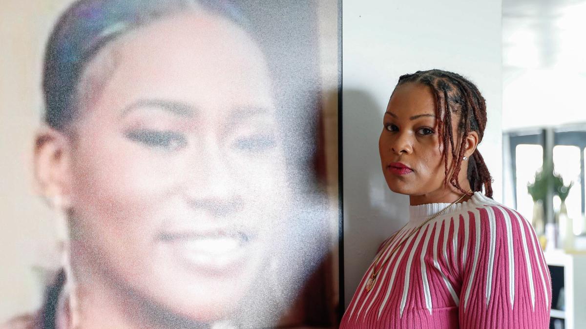 Jenele Hughes poses next to a photograph of her daughter, Amauri Hughes, in her home on Friday, May 17, 2024.