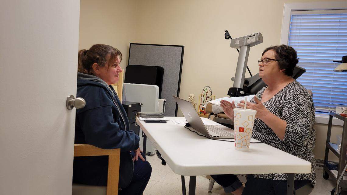 In this October file photo from Mountain View, Mo., Carolyn Hayes, 55, answers questions from Good Samaritan Care Clinic volunteer Vicky Medley, a retired Department of Social Services employee, to fill out an application for Missouri’s expanded Medicaid program. Outreach work to get low-income adults enrolled has fallen to grassroots organizations and clinics serving the poor.