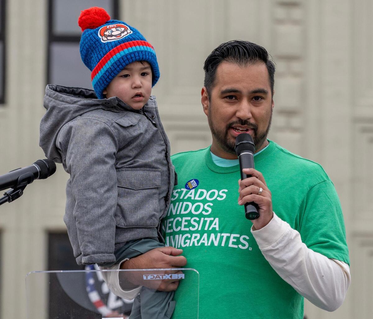 Jackson County Legislator Manuel Abarca IV holds his son while speaking during a rally in support of federal workers on Wednesday, March 12, 2025, in Kansas City.