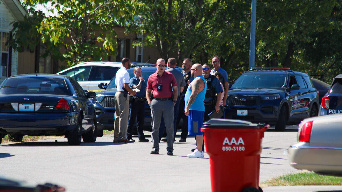 Detectives with the Kansas City Police Department talk to residents in the 8800 block of Northeast 105th Place where a man was found stabbed to death in a home on Oct. 5, 2024.