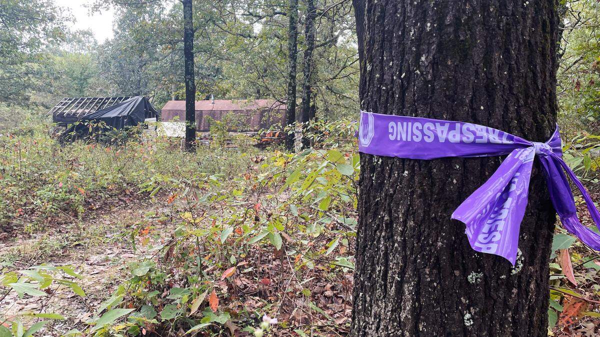 No trespassing tape wrapped the trees surrounding a cabin near Windyville, Missouri, on Sunday. It burned to the ground the next day. Its owner, James Phelps, is charged with kidnapping in the case of Cassidy Rainwater, missing since late August.