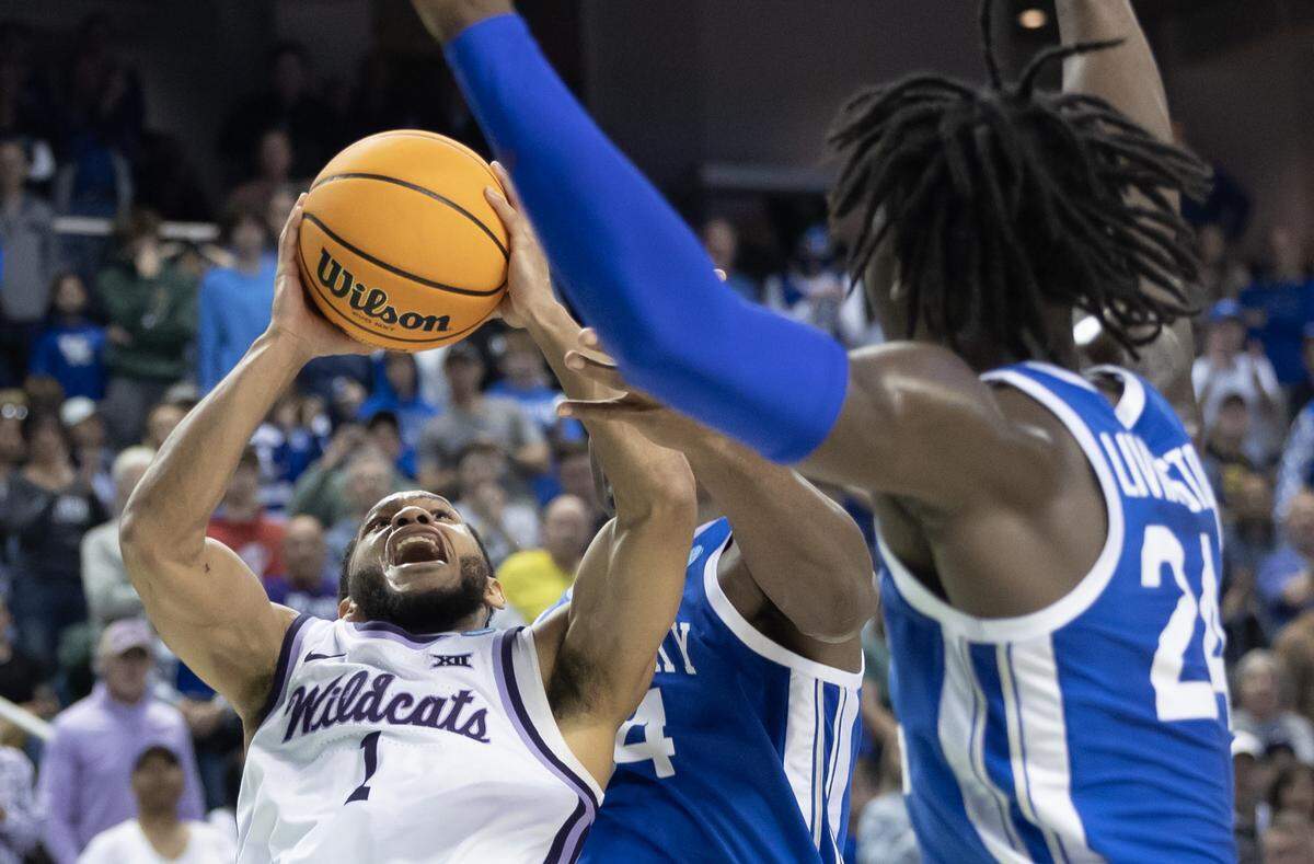 Kansas State’s Markquis Nowell somehow gets a floater to go under heavy defense from Kentucky during the second half of their second round NCAA Tournament game in Greensboro, NC on Sunday.