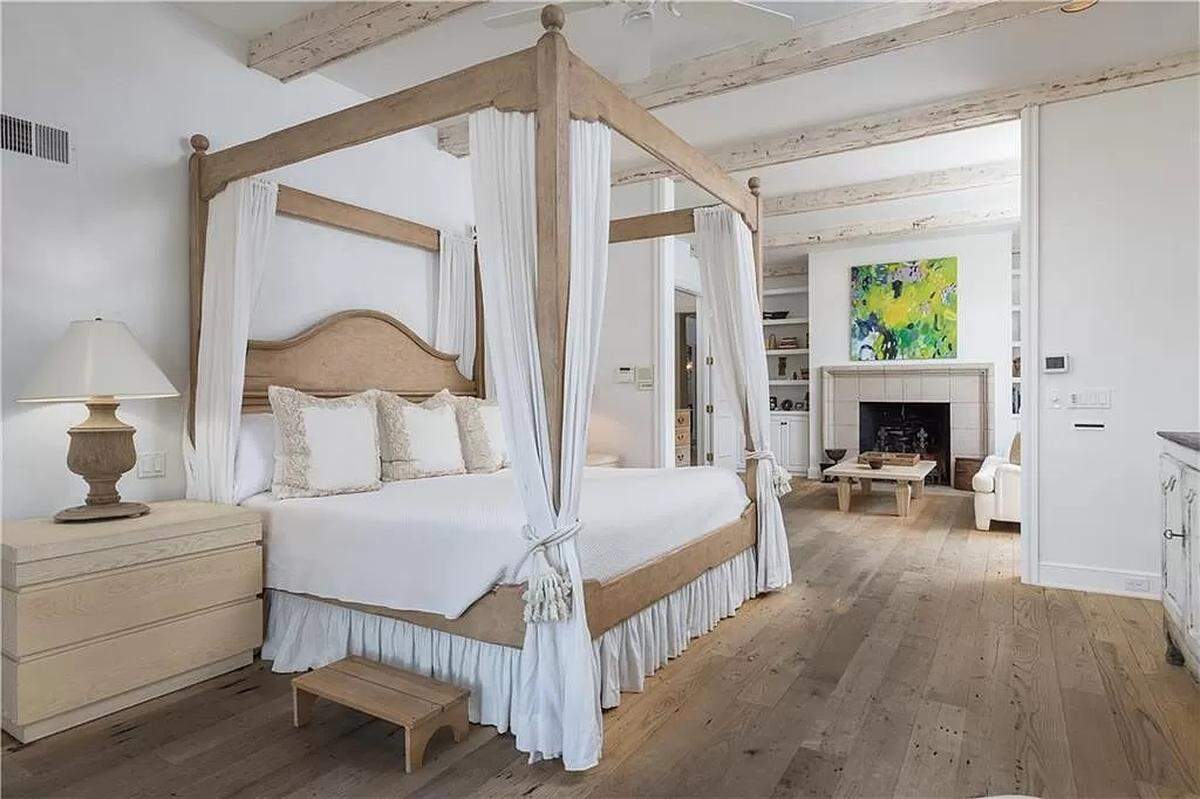 The French-inspired primary bedroom of 2404 W. 114th St. has a fireplace and wood beams.