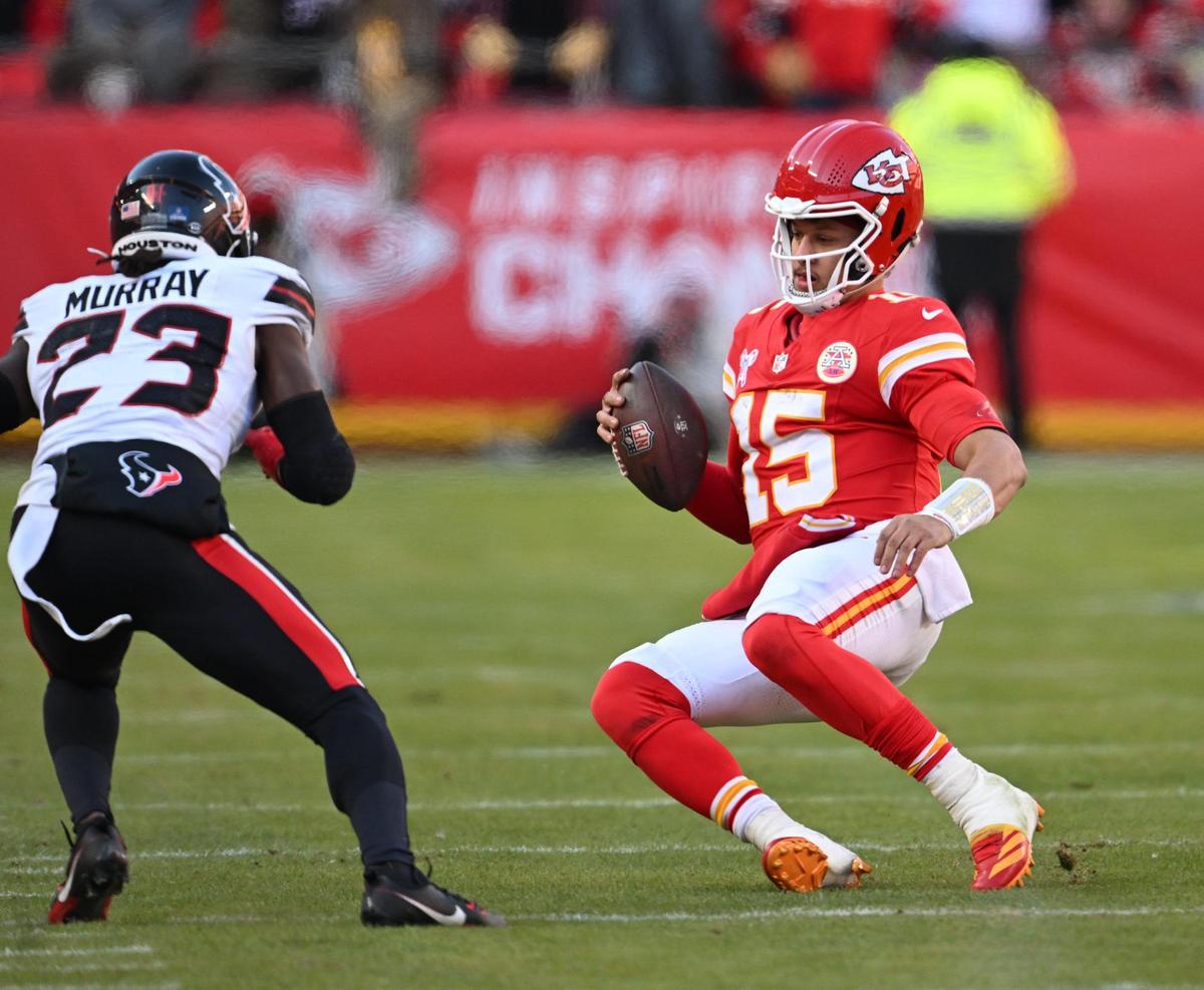 Kansas City Chiefs quarterback Patrick Mahomes (15) slides to avoid a tackle by Houston Texans safety Eric Murray (23) in the second half on Saturday, Dec. 21, 2024, at GEHA Field at Arrowhead Stadium.